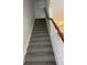 Carpeted stairway leading to the upper level with white railing and wooden banister at 3111 Wentworth Ln, Kissimmee, FL 34741