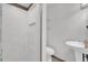 All white bathroom with tiled floors, standing shower, toilet and sink at 320 Granada Dr, Winter Park, FL 32789