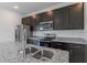 Granite countertops and stainless steel appliances adorn this stylish kitchen with dark cabinetry and a center island at 3389 Sw 126Th Lane Rd, Ocala, FL 34473