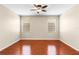 Bedroom featuring hardwood floors, neutral paint, a ceiling fan, and natural light from two windows at 4027 Sunrise Ridge Blvd, Groveland, FL 34736