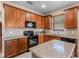 Well-equipped kitchen with stainless-steel appliances, granite countertops, tile backsplash, and custom wood cabinetry at 4027 Sunrise Ridge Blvd, Groveland, FL 34736