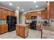 Modern kitchen featuring an island with stone accents, granite countertops, tile flooring, and stainless-steel appliances at 4027 Sunrise Ridge Blvd, Groveland, FL 34736