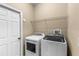 Functional laundry room featuring a washer, dryer, and storage shelf at 4027 Sunrise Ridge Blvd, Groveland, FL 34736