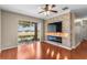 Bright living room with a stone accent wall, electric fireplace, and sliding glass doors to the patio at 4027 Sunrise Ridge Blvd, Groveland, FL 34736