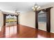 Spacious living room featuring hardwood floors, decorative chandelier, and large windows with stylish curtains at 4027 Sunrise Ridge Blvd, Groveland, FL 34736