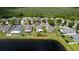 Scenic aerial view showcases a home near a pond, surrounded by lush greenery and other houses at 4060 Longworth Loop, Kissimmee, FL 34744