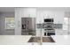 Stylish kitchen boasts stainless steel appliances, quartz countertops, and a tiled backsplash at 4060 Longworth Loop, Kissimmee, FL 34744