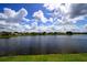 Beautiful lake view with a backdrop of a suburban neighborhood and a cloudy sky at 4060 Longworth Loop, Kissimmee, FL 34744