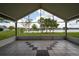 Enclosed patio with tile flooring offering serene views of the backyard and lake at 4060 Longworth Loop, Kissimmee, FL 34744