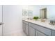 Well-lit bathroom with double vanity, a large mirror, and modern fixtures at 4220 Paragraph Dr, Kissimmee, FL 34746