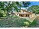 Expansive backyard features a covered patio, lush lawn, and mature trees providing ample shade at 466 Drexel Ridge Cir, Ocoee, FL 34761