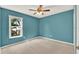 Bright teal bedroom features neutral carpeting and a sunny window view at 466 Drexel Ridge Cir, Ocoee, FL 34761