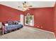 Red bedroom features a bed, a window and neutral carpeting at 466 Drexel Ridge Cir, Ocoee, FL 34761