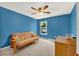 A blue bedroom with a ceiling fan, a sofa bed and a window at 466 Drexel Ridge Cir, Ocoee, FL 34761