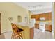 Bright kitchen with wood cabinets, white appliances, breakfast bar, and neutral tile flooring at 466 Drexel Ridge Cir, Ocoee, FL 34761