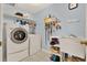 Bright laundry room features a washer, dryer, utility sink, and ample shelving for storage at 466 Drexel Ridge Cir, Ocoee, FL 34761