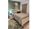 Bedroom showcasing a comfy bed, olive green accent wall, and calming decor at 4800 S Semoran Blvd # 101, Orlando, FL 32822