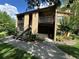 Exterior view of condo highlighting balconies, landscaping, and easy access via walkway and stairs at 4800 S Semoran Blvd # 101, Orlando, FL 32822
