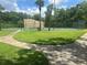 View of community tennis court surrounded by palm trees and green space at 4800 S Semoran Blvd # 101, Orlando, FL 32822