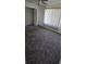 Spacious carpeted bedroom with a ceiling fan, walk-in closet, and bright natural light at 4906 Gifford Blvd, Orlando, FL 32821
