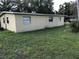 An exterior view of the side and backyard of the home, showing the siding, lawn, and a few trees at 530 Ruffel St, Maitland, FL 32751