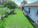 Expansive backyard with lush green grass and a white fence, with storage sheds along the home's exterior at 543 Auburn Hill Blvd, Auburndale, FL 33823