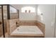 Soaking tub in bathroom, featuring tiled surround, window, and separate shower, creating a spa-like retreat at 543 Auburn Hill Blvd, Auburndale, FL 33823