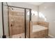 Bathroom with a glass-enclosed shower and a tiled soaking tub, designed for relaxation and comfort at 543 Auburn Hill Blvd, Auburndale, FL 33823