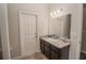 This bathroom features tile flooring, a granite vanity with dark cabinets, and a decorative mirror at 543 Auburn Hill Blvd, Auburndale, FL 33823