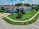 Aerial view of a blue house with a 2-car garage, green grass and a landscaped front yard at 543 Auburn Hill Blvd, Auburndale, FL 33823