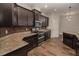 Modern kitchen featuring granite counters, stainless steel appliances, and dark cabinetry with tile backsplash at 543 Auburn Hill Blvd, Auburndale, FL 33823