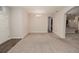 Open-concept living room with neutral carpet and an arched doorway to the kitchen at 543 Auburn Hill Blvd, Auburndale, FL 33823