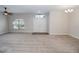 Spacious living room features neutral carpet, ceiling fan and a bright window at 543 Auburn Hill Blvd, Auburndale, FL 33823