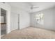 This bedroom offers neutral carpet and walls, a ceiling fan, and a large window for plenty of sunlight at 5524 Metrowest Blvd # 210, Orlando, FL 32811