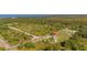 Sweeping aerial view highlighting a home with a circular driveway, lush trees, and a road at 6273 Toronja Dr, Indian Lake Estates, FL 33855
