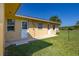 Exterior shot of the rear of the home with two doors and a window at 6273 Toronja Dr, Indian Lake Estates, FL 33855