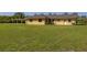 Large backyard lawn behind this single Gathering home with three doors at 6273 Toronja Dr, Indian Lake Estates, FL 33855