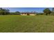 Single Gathering home featuring a large backyard lawn and a covered carport at 6273 Toronja Dr, Indian Lake Estates, FL 33855