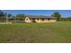 Spacious green lawn behind this single Gathering home with an attached carport at 6273 Toronja Dr, Indian Lake Estates, FL 33855
