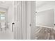 Hallway view of renovated bathroom featuring white tiled floors and white door, next to a bedroom at 6273 Toronja Dr, Indian Lake Estates, FL 33855