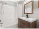 Bathroom featuring wood vanity, shower, bathtub with white tile and modern fixtures at 6273 Toronja Dr, Indian Lake Estates, FL 33855
