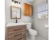 Well-lit bathroom featuring a modern vanity, mirror, toilet, and window at 6273 Toronja Dr, Indian Lake Estates, FL 33855