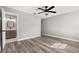 Spacious bedroom with modern ceiling fan, wood-look floors, and ensuite bathroom at 6273 Toronja Dr, Indian Lake Estates, FL 33855