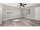 Clean bedroom with laminate flooring, a ceiling fan, and two windows for ample natural light at 6273 Toronja Dr, Indian Lake Estates, FL 33855