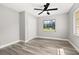 Charming bedroom with wood-look floors, a ceiling fan, and a window with a backyard view at 6273 Toronja Dr, Indian Lake Estates, FL 33855