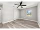Bedroom with wood-look floors, ceiling fan, closet and a window, creating a comfortable space at 6273 Toronja Dr, Indian Lake Estates, FL 33855