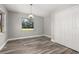 Inviting bedroom with wood-look floors and a closet, illuminated by natural light from two windows at 6273 Toronja Dr, Indian Lake Estates, FL 33855