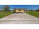 Carport attached to a home surrounded by a large green lawn at 6273 Toronja Dr, Indian Lake Estates, FL 33855