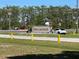 Elegant entrance sign for Indian Lake Estates surrounded by greenery and street access at 6273 Toronja Dr, Indian Lake Estates, FL 33855