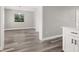 Bright dining room featuring wood-look floors and a window overlooking the front yard at 6273 Toronja Dr, Indian Lake Estates, FL 33855